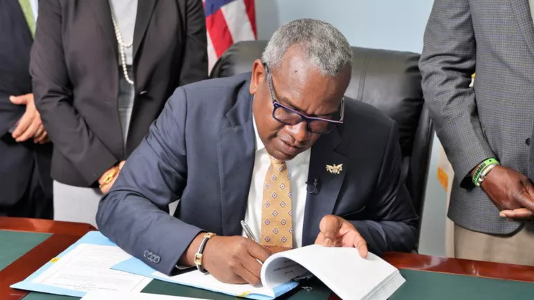 Photo du gouverneur signant le d&eacute;cret