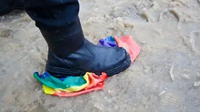Une botte &eacute;crasant un drapeau arc-en-ciel
